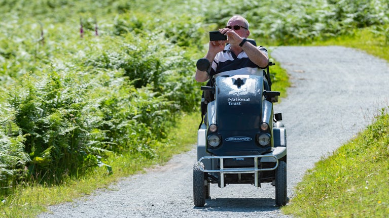 Visitor exploring a trail in an all-terrain mobility scooter